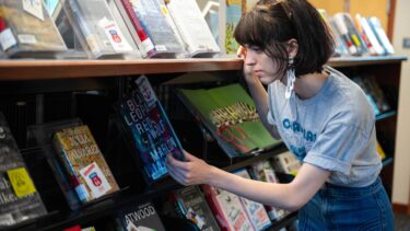 a student browsing the fiction books in the library