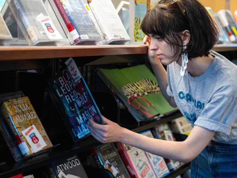a student browsing the fiction books in the library