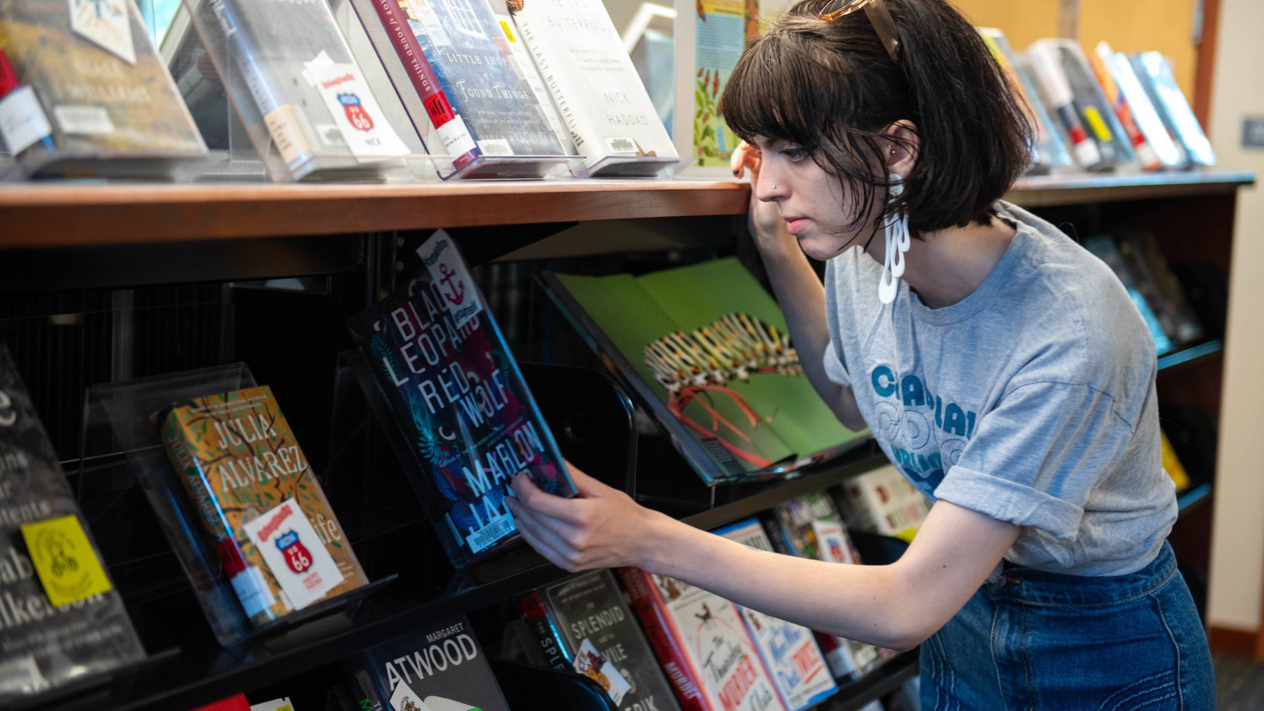 a student browsing the fiction books in the library