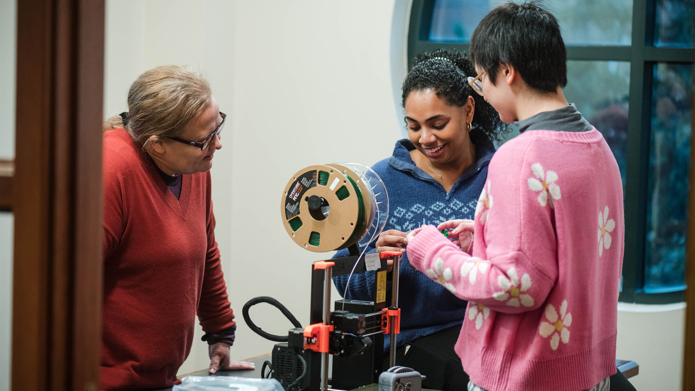 Students and an instructor working on a 3D printed project
