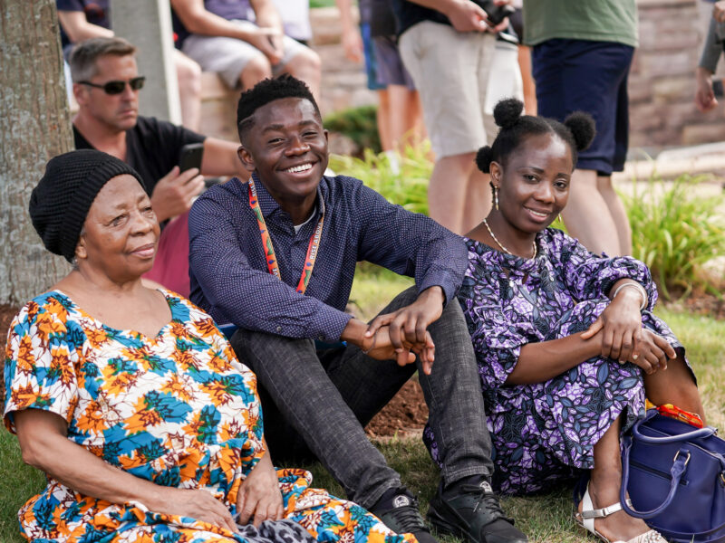 family sits on the lawn at orientation