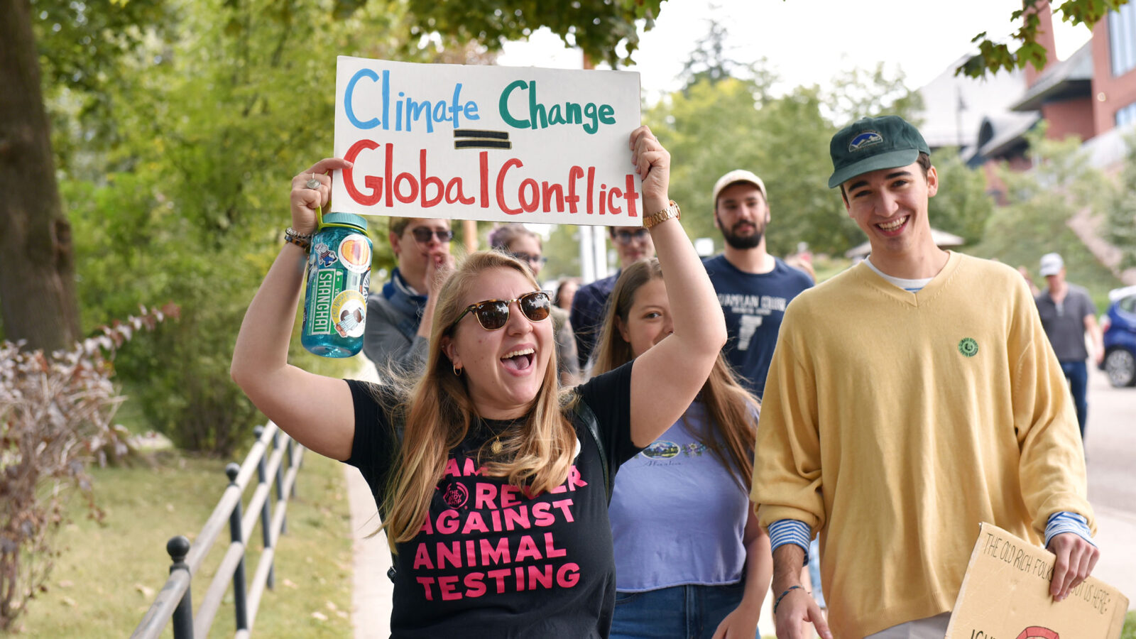 students marching through burlington rallying for climate change with signs