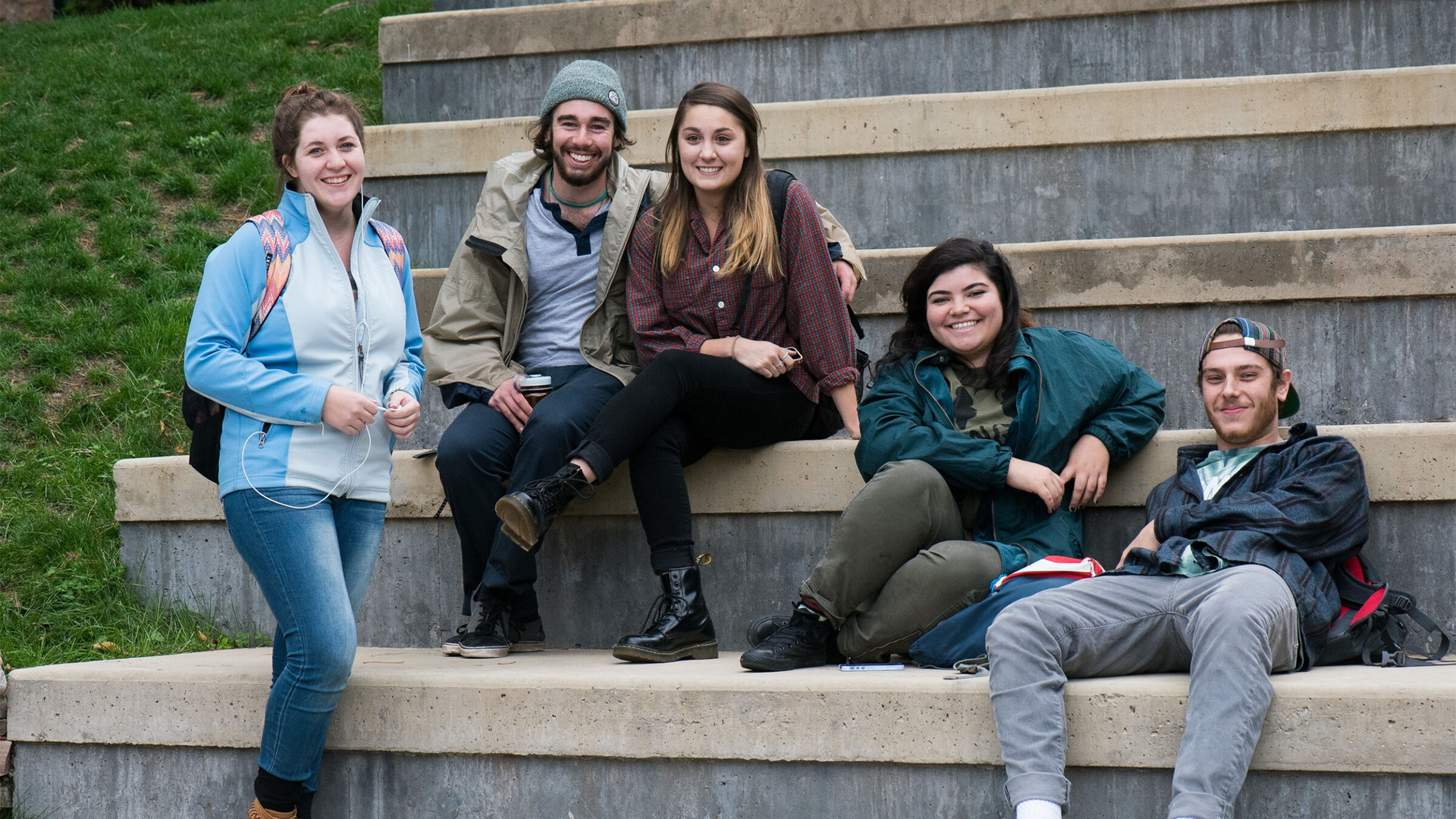 a small group of students relaxing outside on bleachers