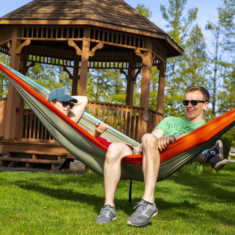 two student enjoy a sunny day in a hammock