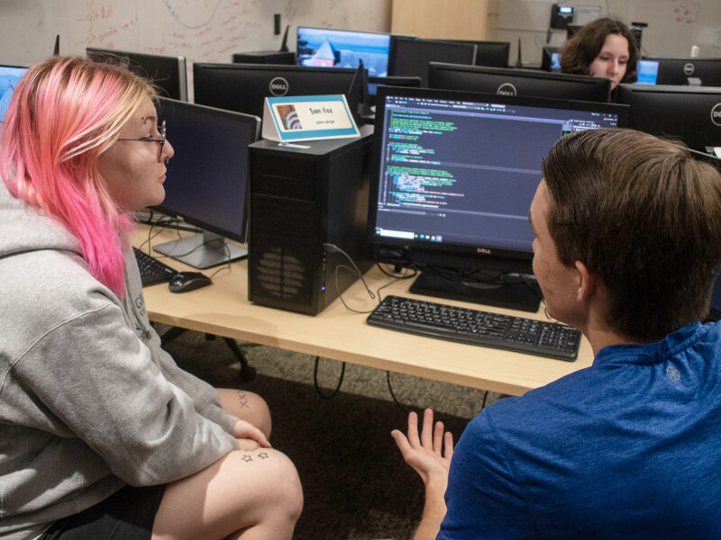 students talk about computer programming in the tutoring center