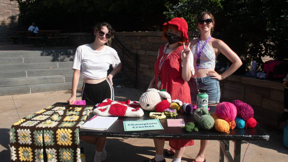 students posing with yarn and crochet projects at the activity fair