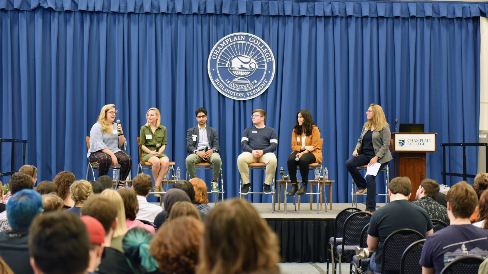 Champlain students sit on stage at the Sophomore Summit for a discussion about careers