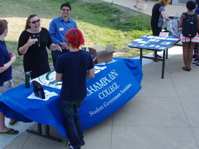 Students outside finny quad tabling for the student government association with interested students chatting