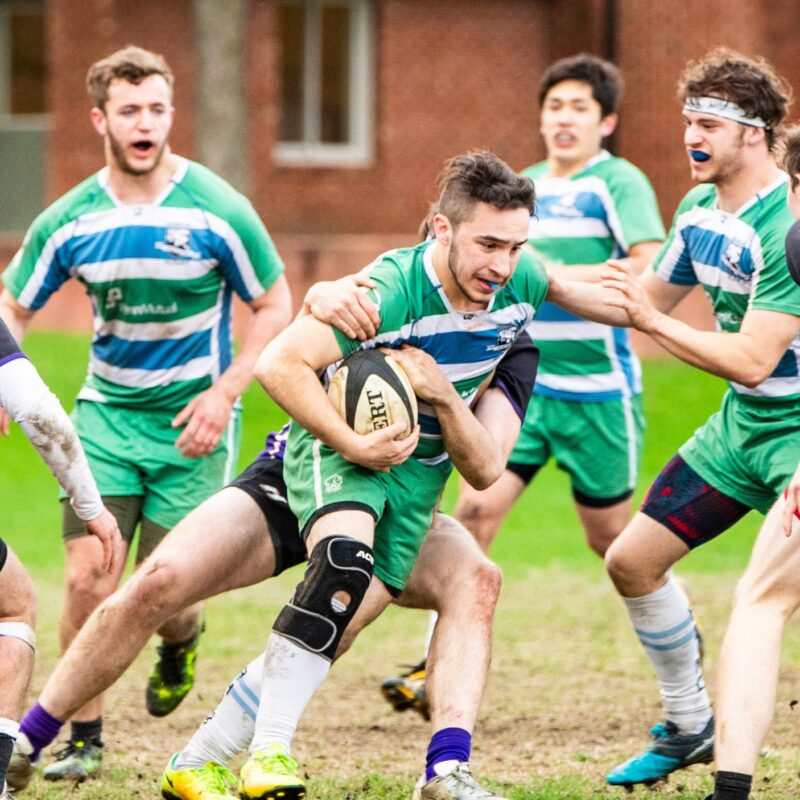 student intramural rugby player defending the ball