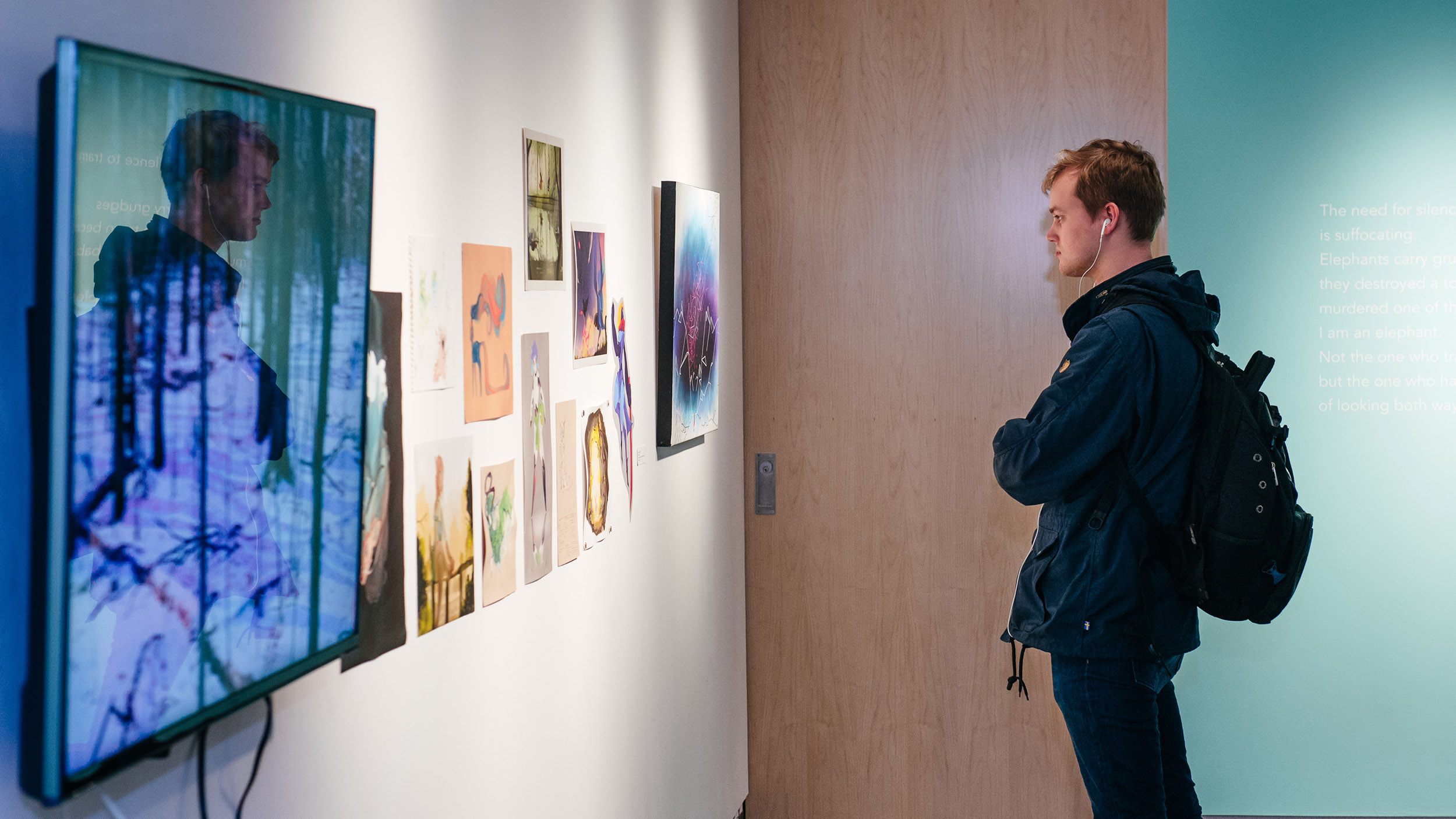 student views art hanging on a gallery wall