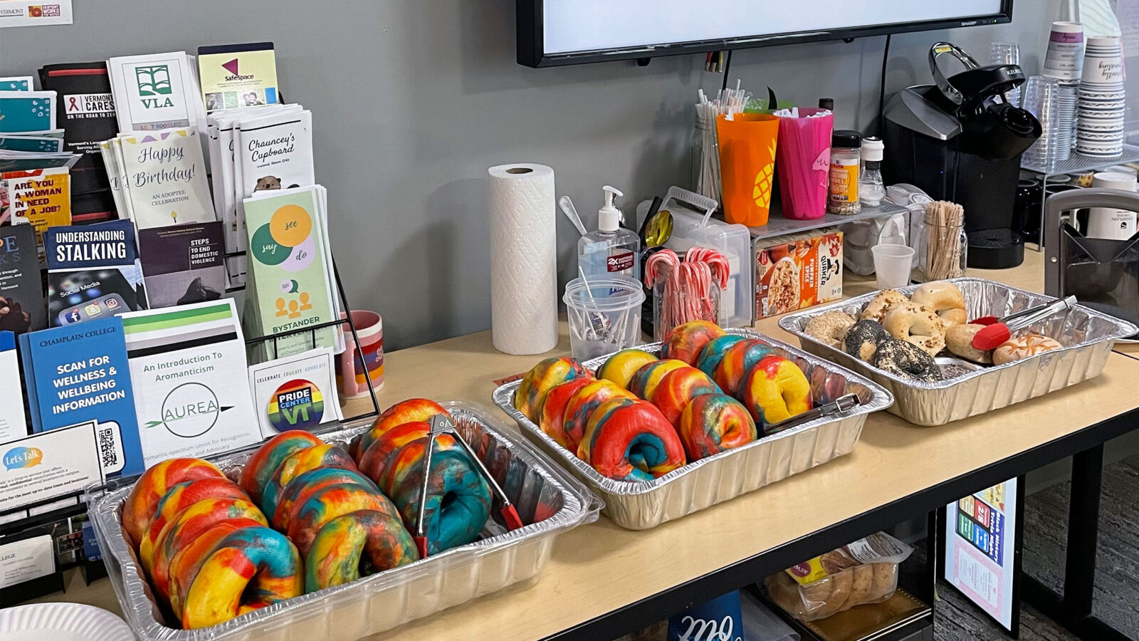 two trays of rainbow bagels sit on a table in the women's and gender center