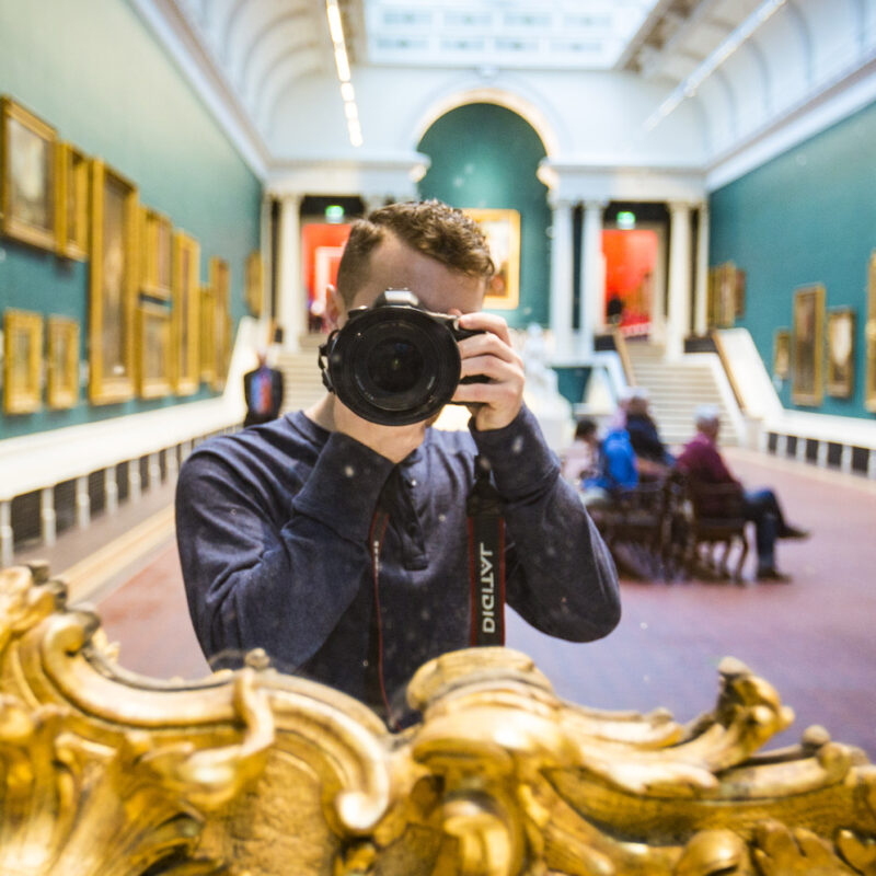 student photographs self in a mirror