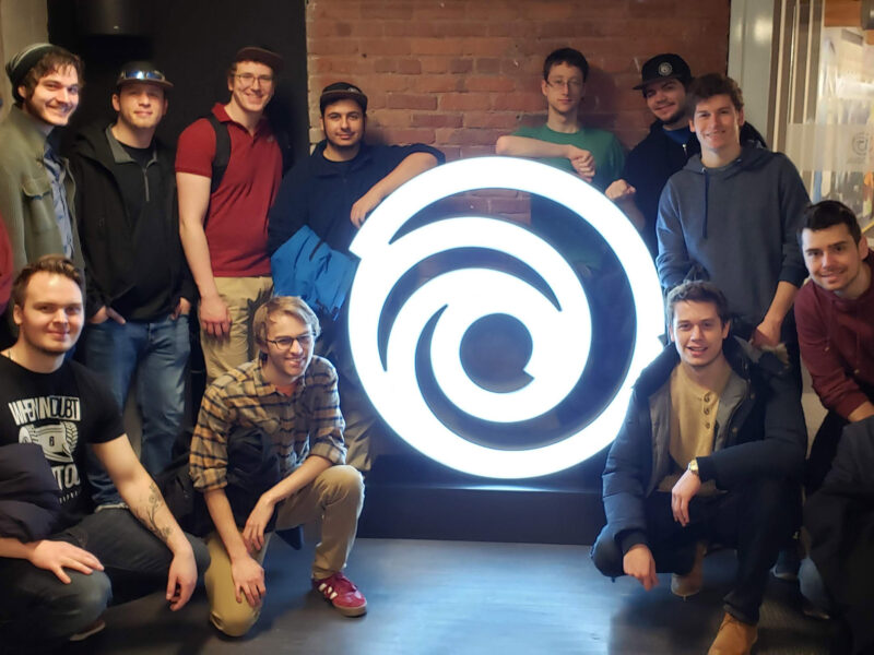 group of students pose around the Ubisoft logo
