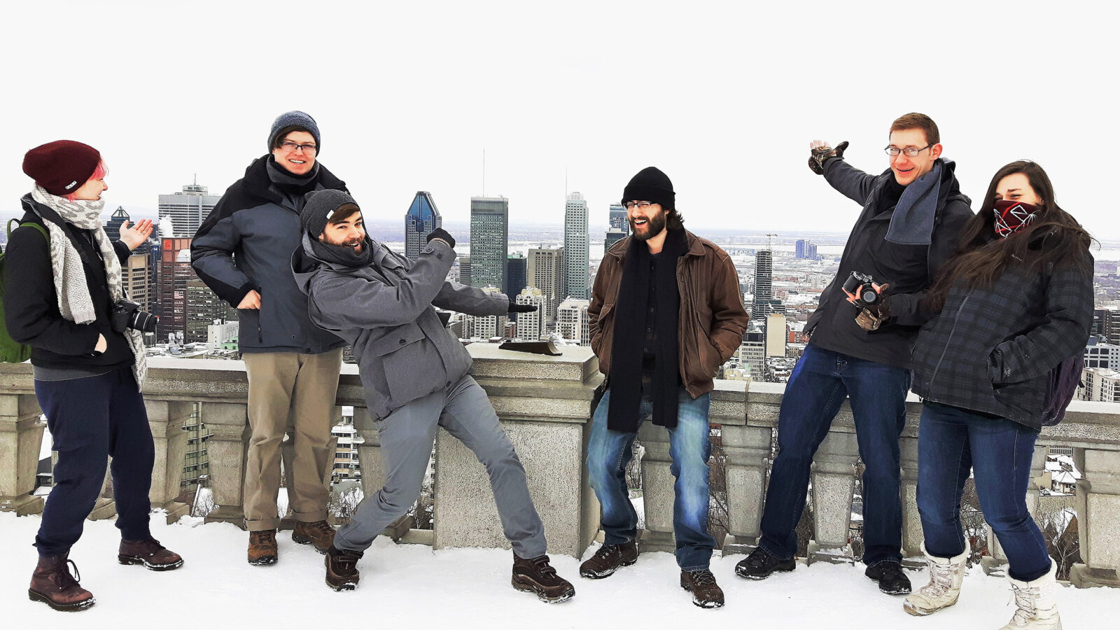 group of students gesture to the view from Mt. Royal in Montreal, snowy day