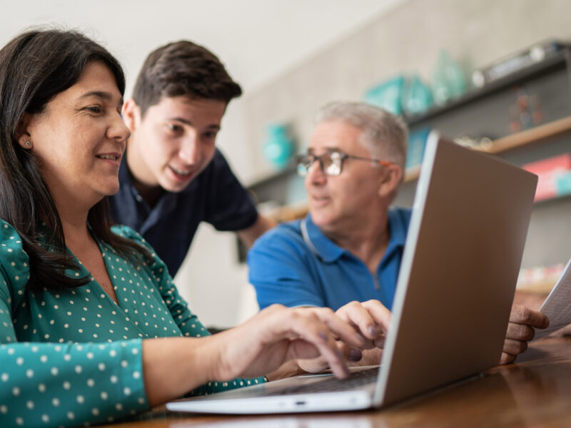 Parents doing home finances and talking to teenager son