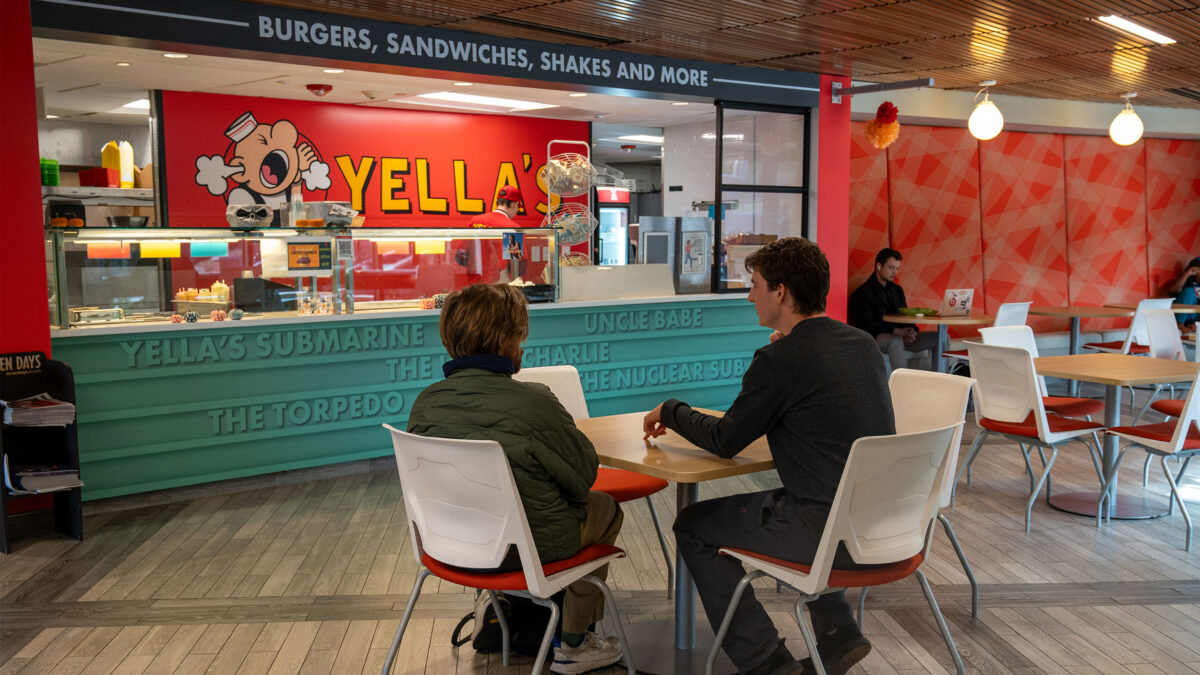 yella's dining area with red and blue walls, two students sitting at table