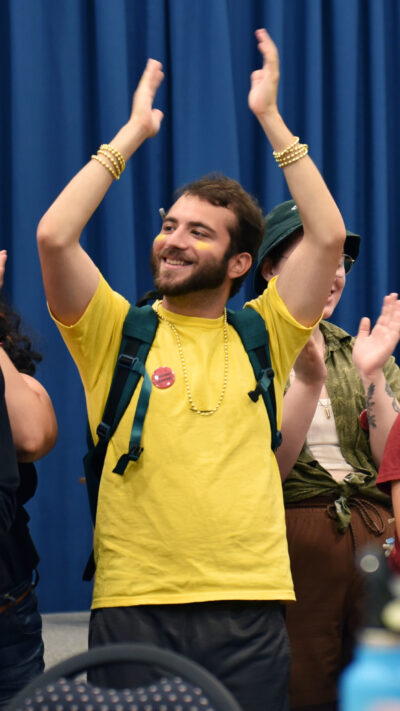 a student raises his arms in the air to applaud