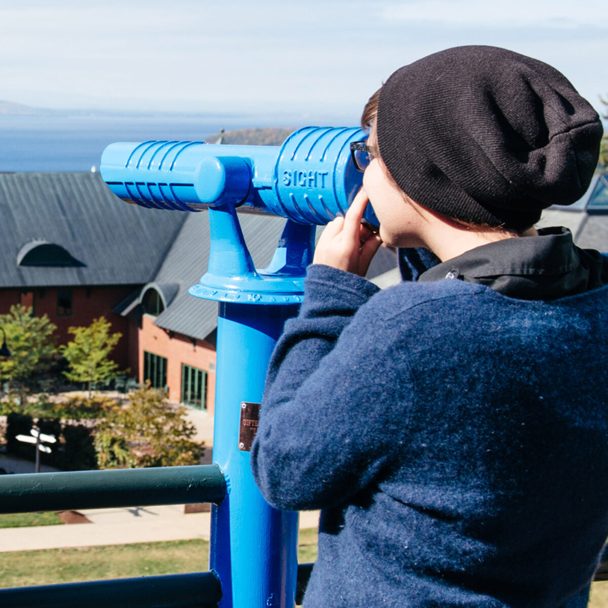 a student uses a telescope on the library balcony
