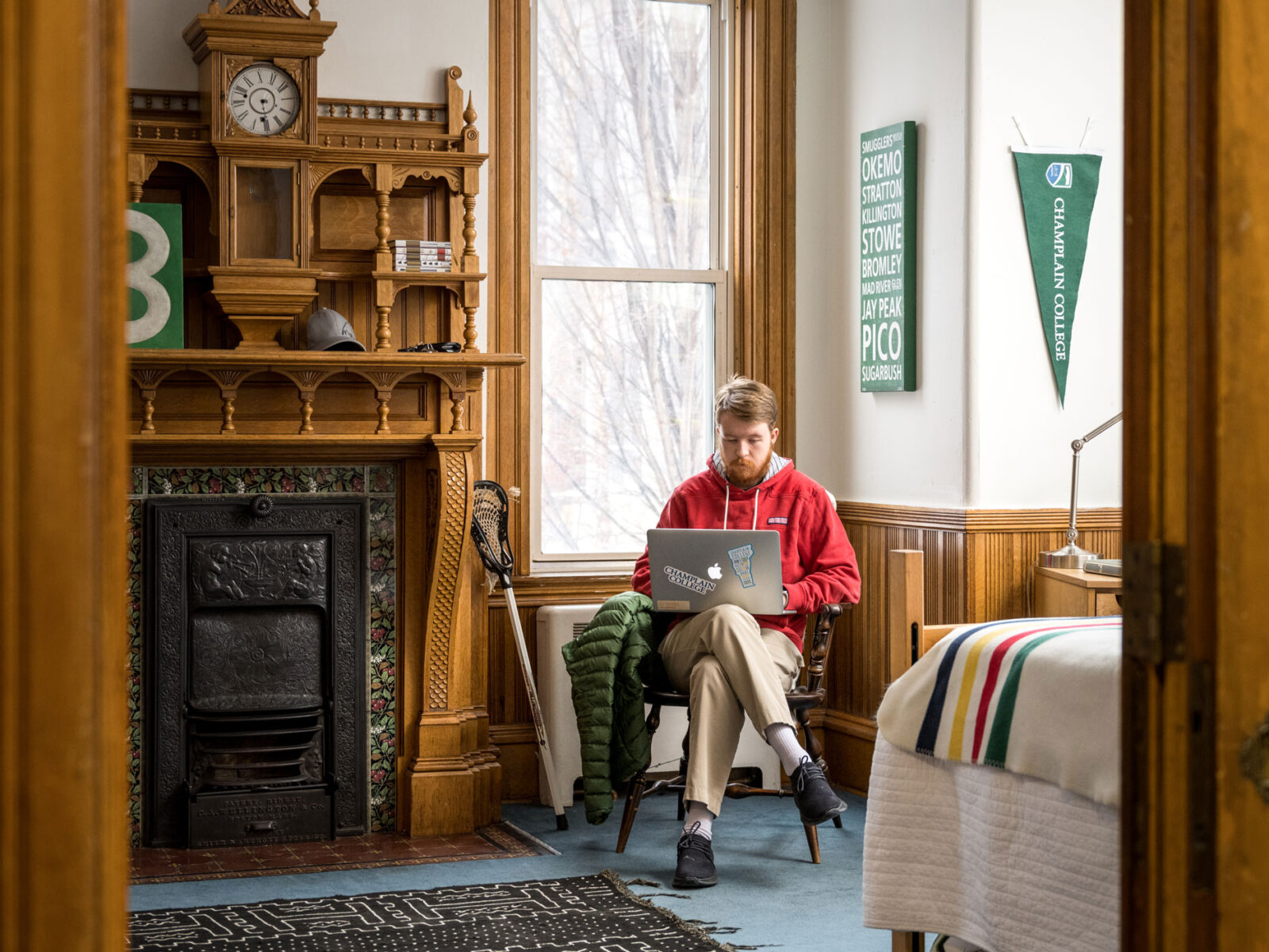 A student studies in his stately, dorm room, which includes an elaborate fireplace.