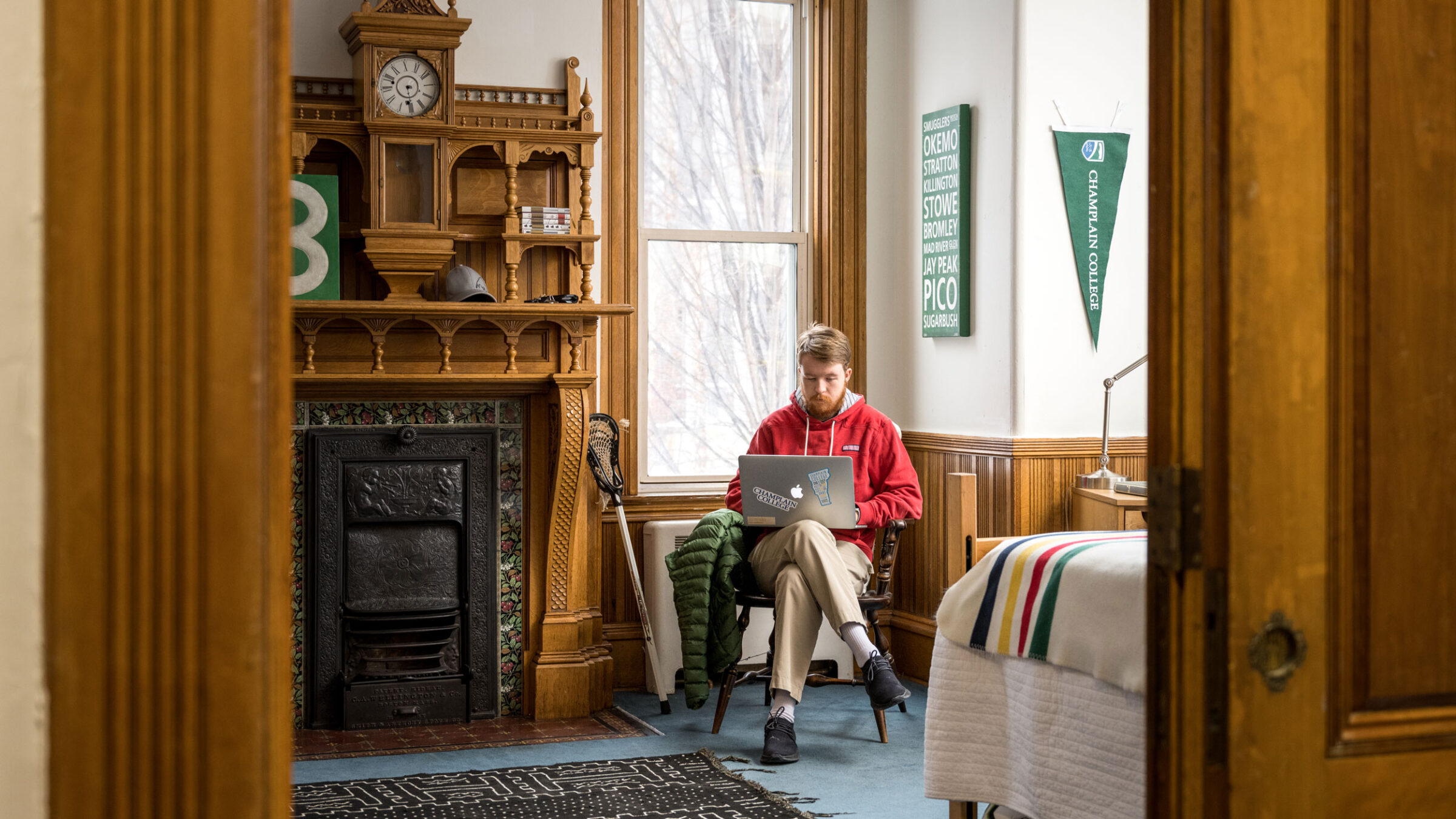 A student studies in his stately, dorm room, which includes an elaborate fireplace.