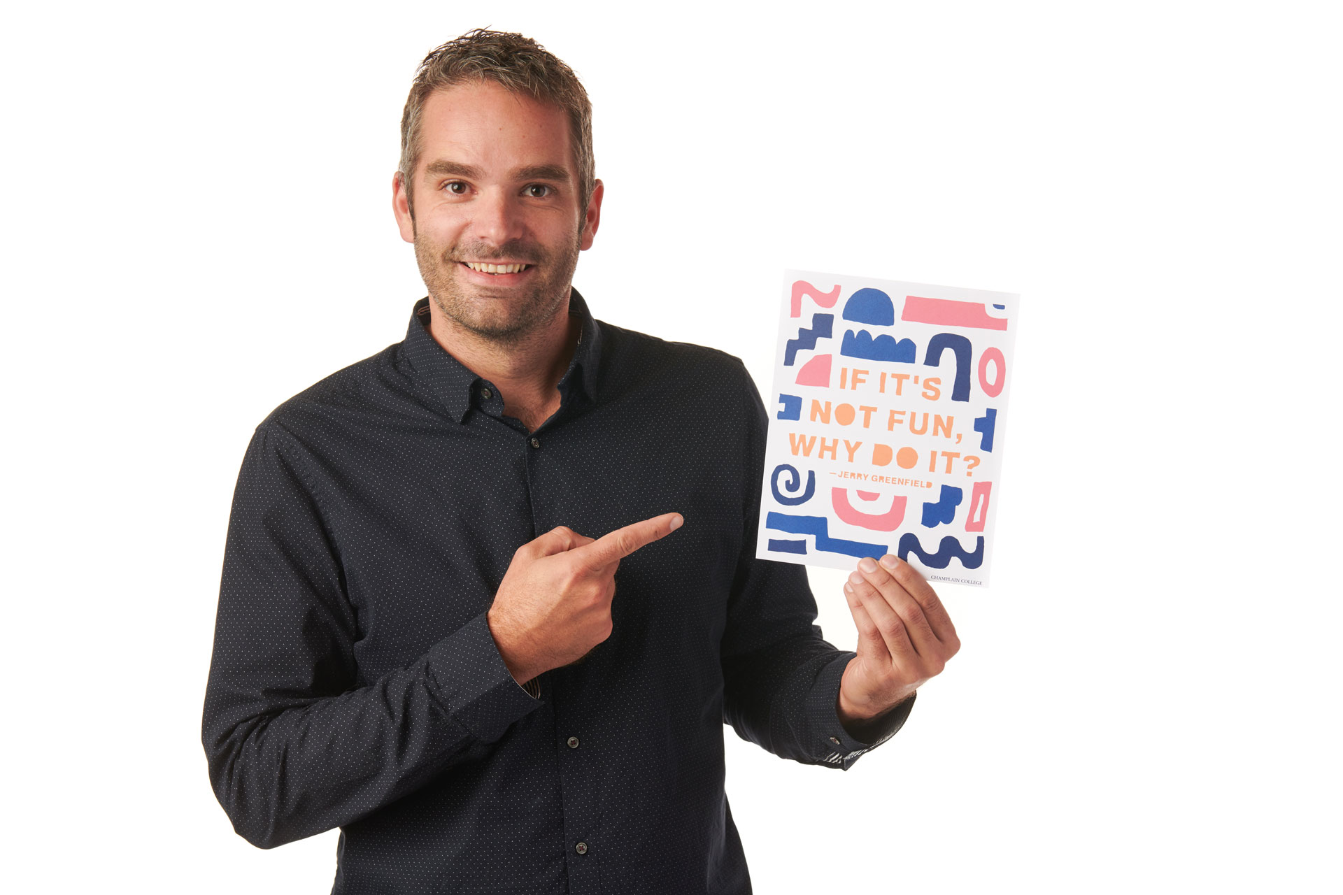 Dr. Cyrus Patten holding a postcard that reads "If it's not fun, why do it?"