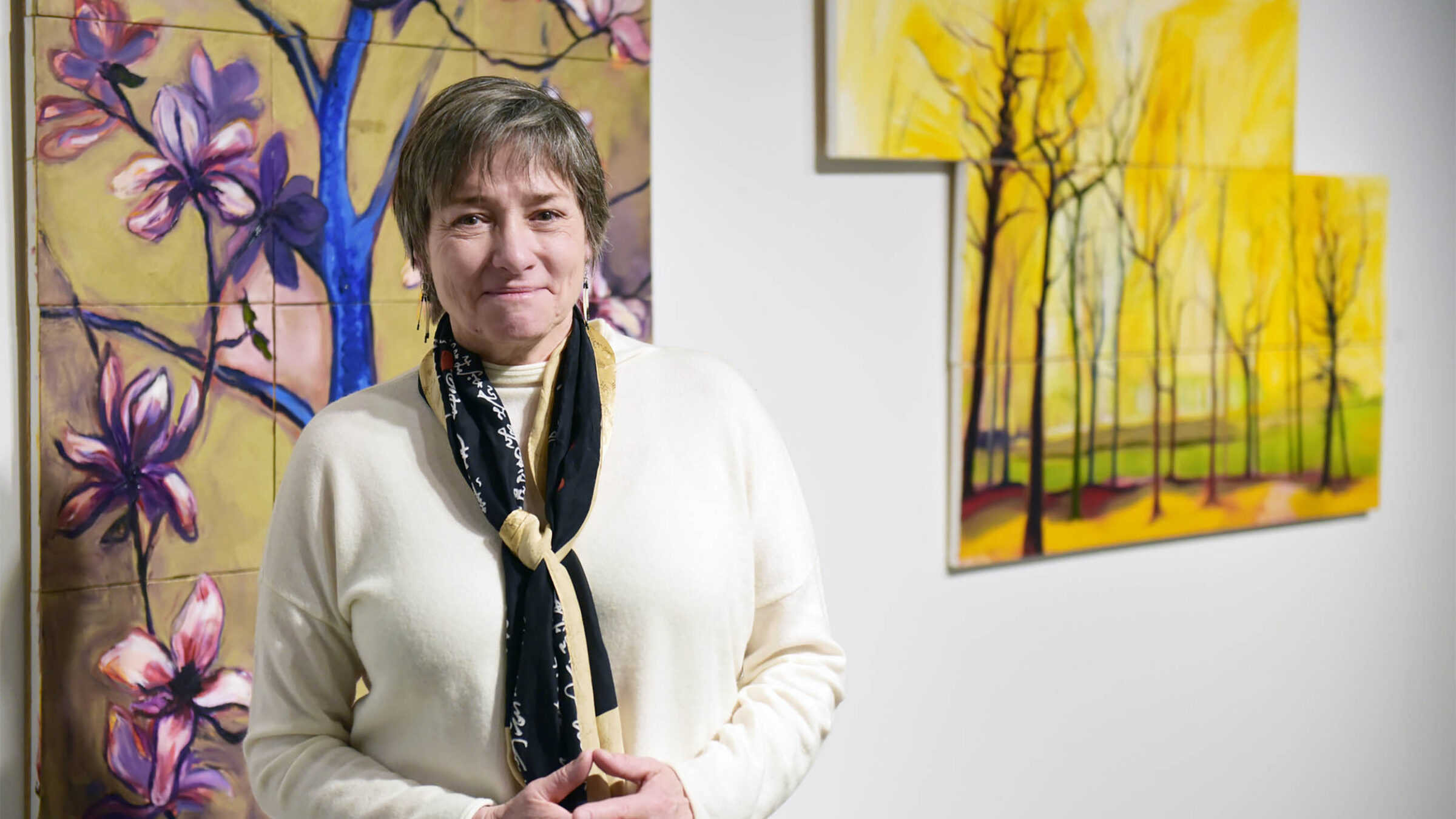 Ann DeMarle standing in front of artwork