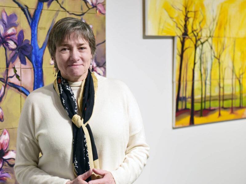 Ann DeMarle standing in front of artwork