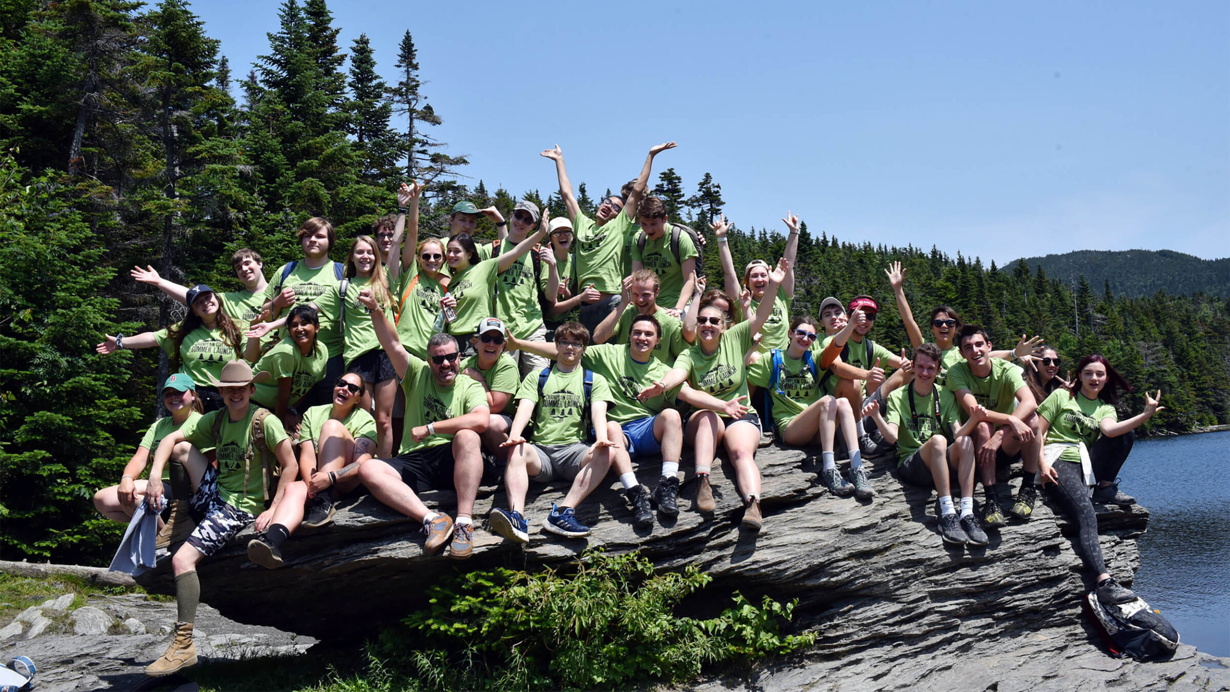 student orientation leaders posing on a rock in the vermont wilderness
