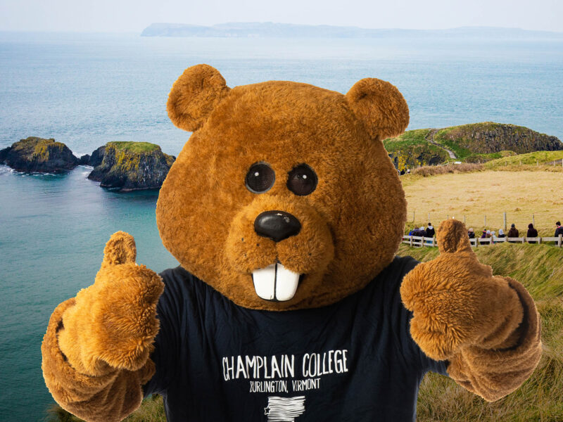 Champlain's mascot, Chauncy, giving a thumbs up in front of a photo from Dublin, Ireland