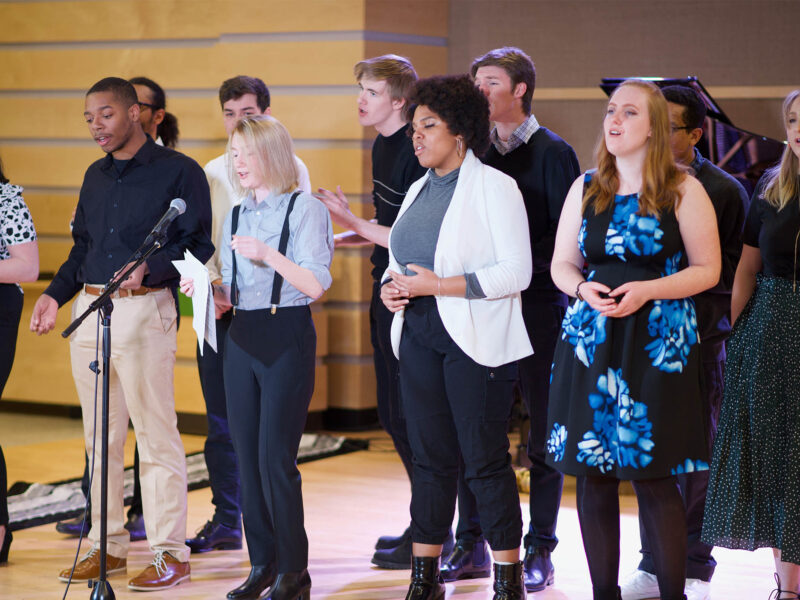 a group of students singing on stage