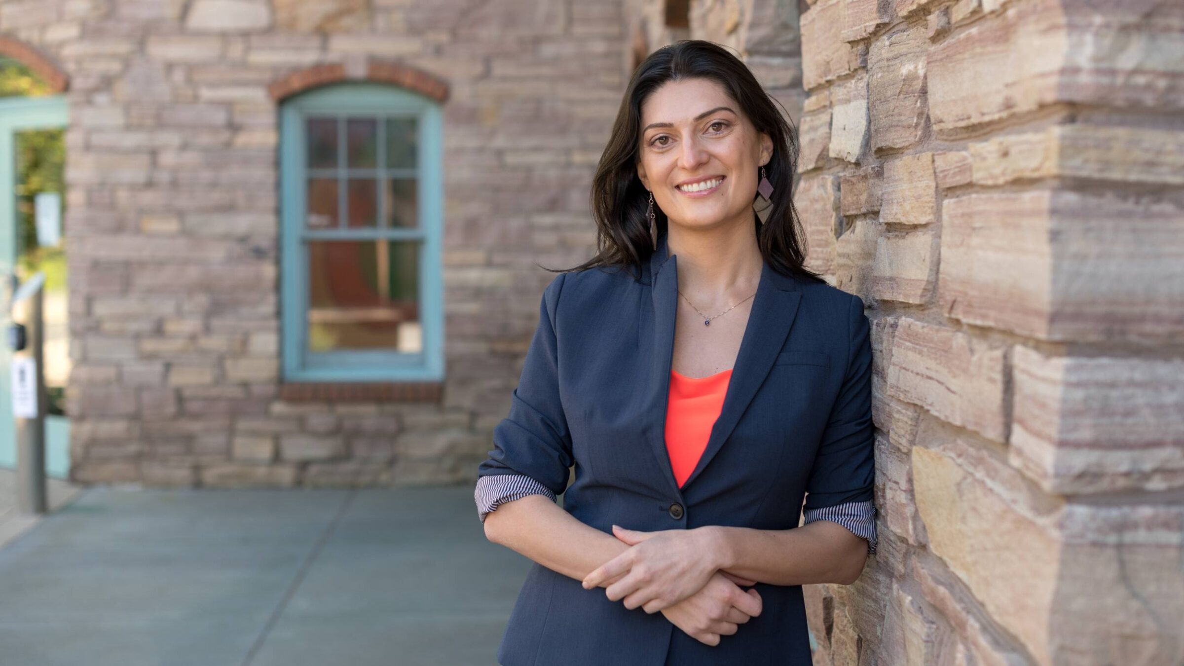 a Champlain faculty member leaning against a brick wall