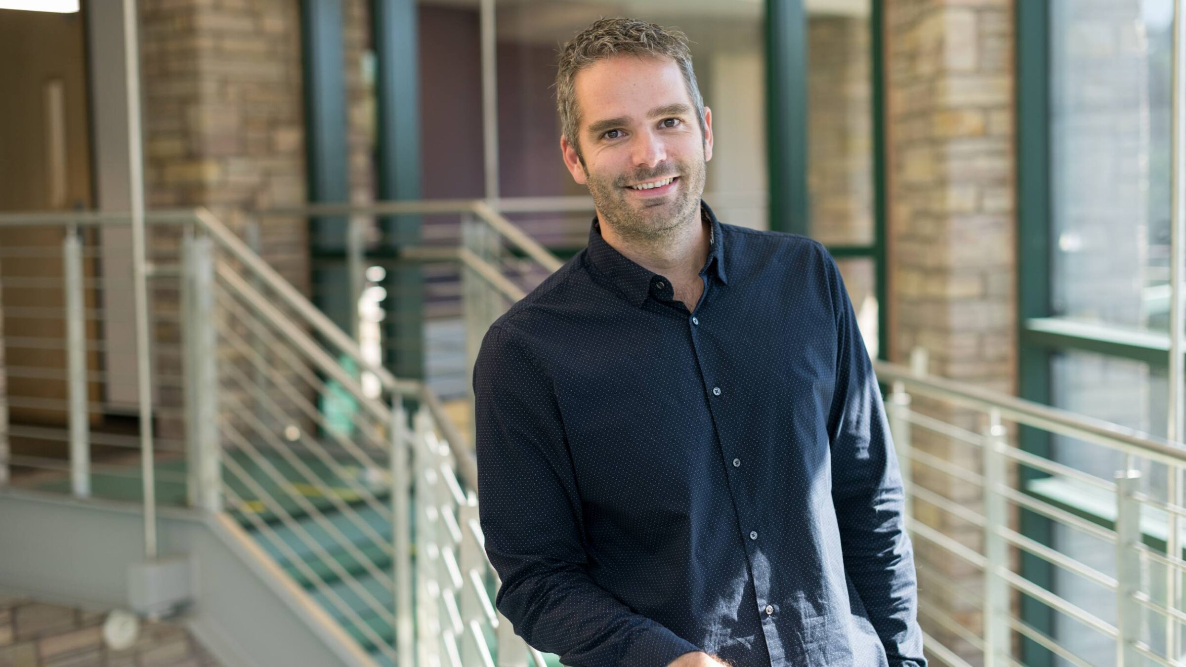 Dr. Cyrus Patten leaning against a railing in CCM