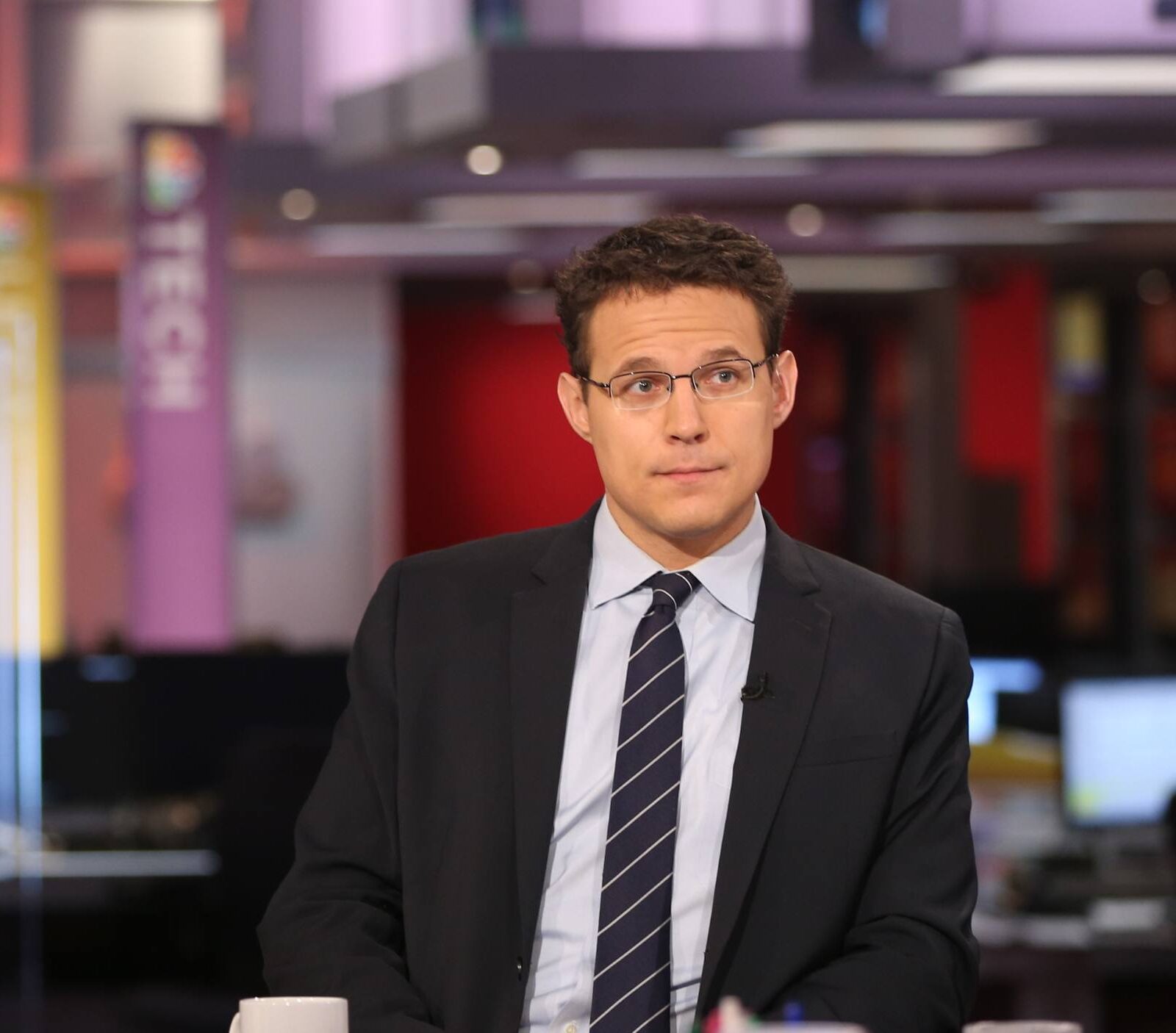 a person sitting at a new table wearing a suit and tie