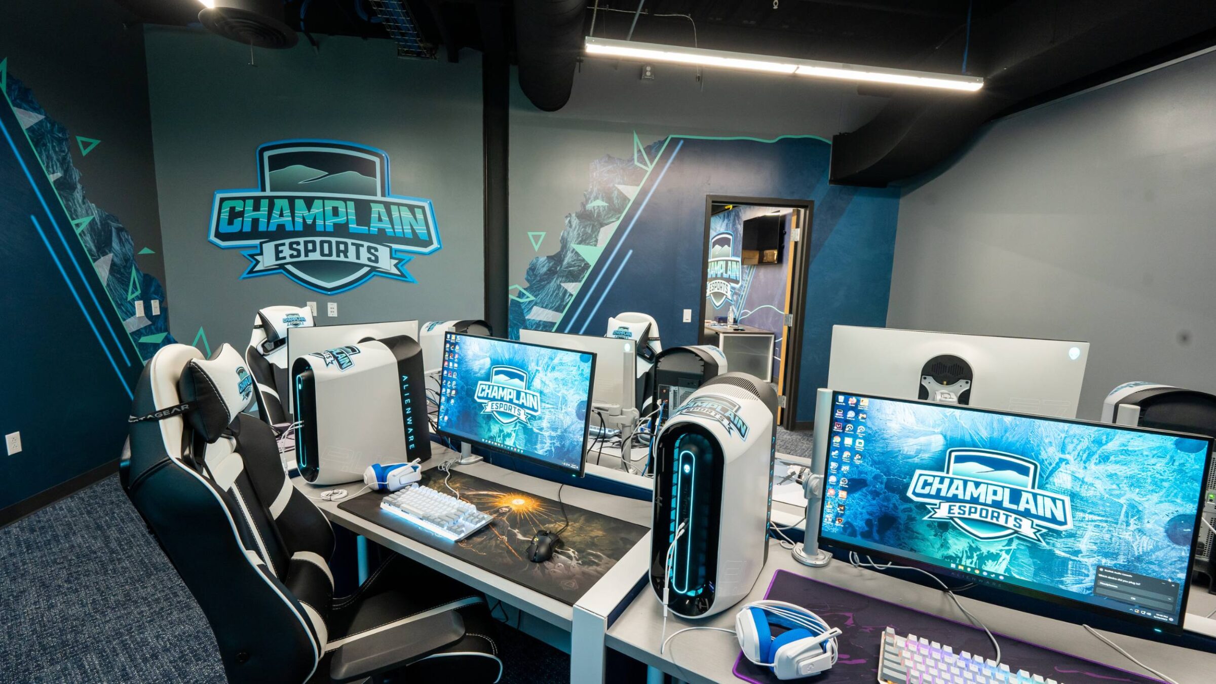 champlain's esports room with white computers, monitors, and keyboards