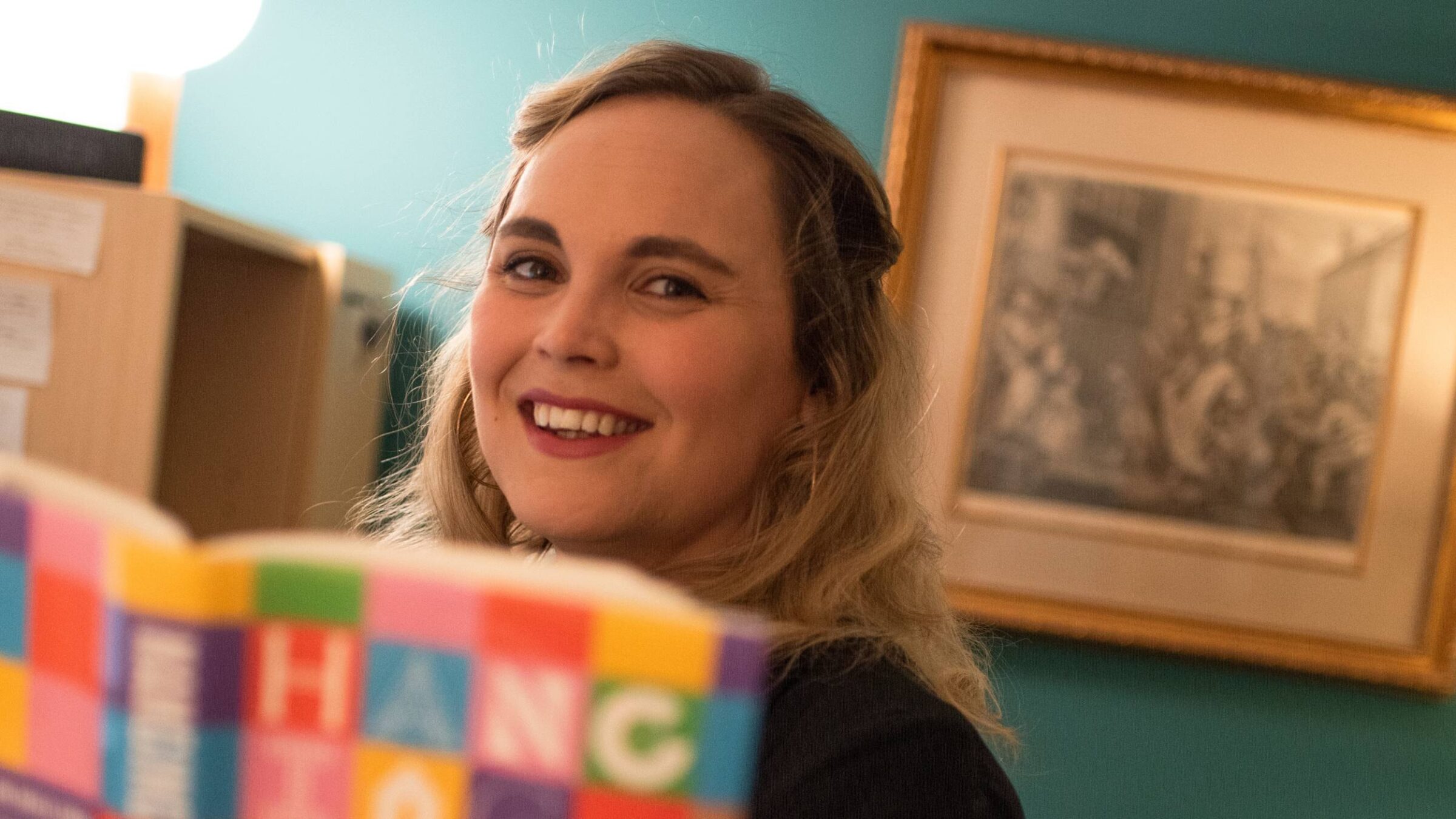 Sheila Liming holding a book in her office