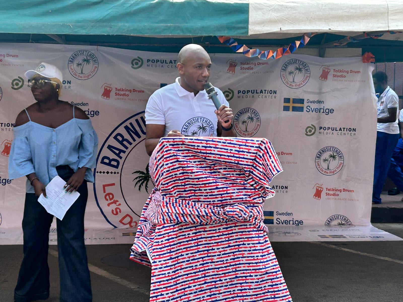 Jean Luc Dushime speaks at a podium in Liberia.
