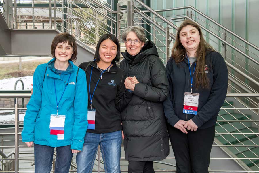 a group standing in CCM leaning against the railing