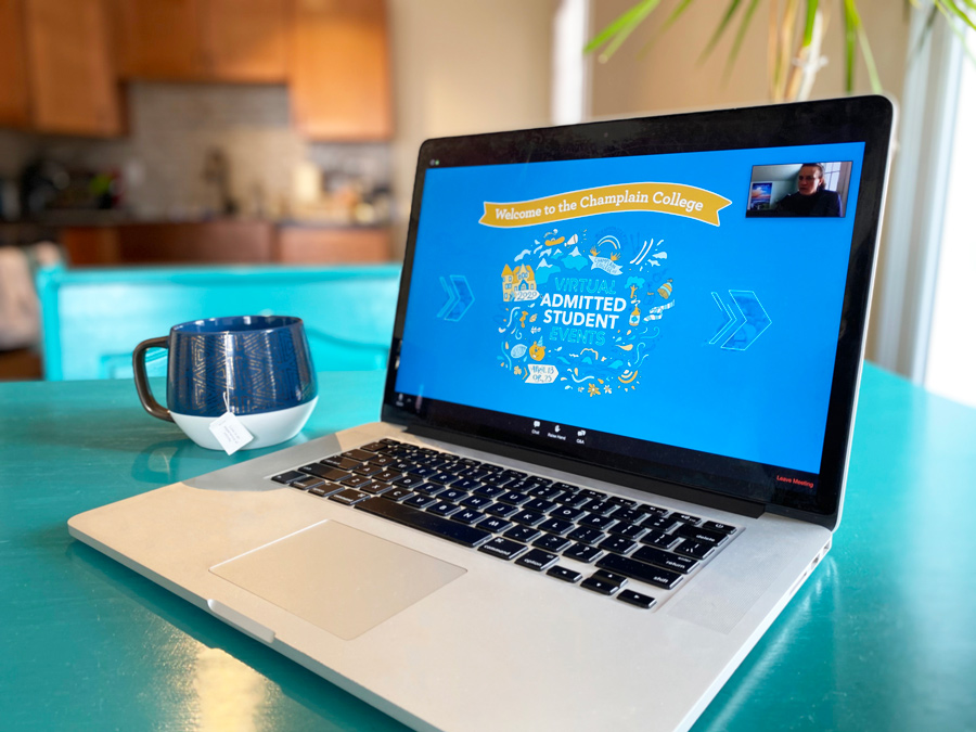 an open laptop with a zoom call of Virtual Admitted Student events on a blue table with a cup of tea nearby