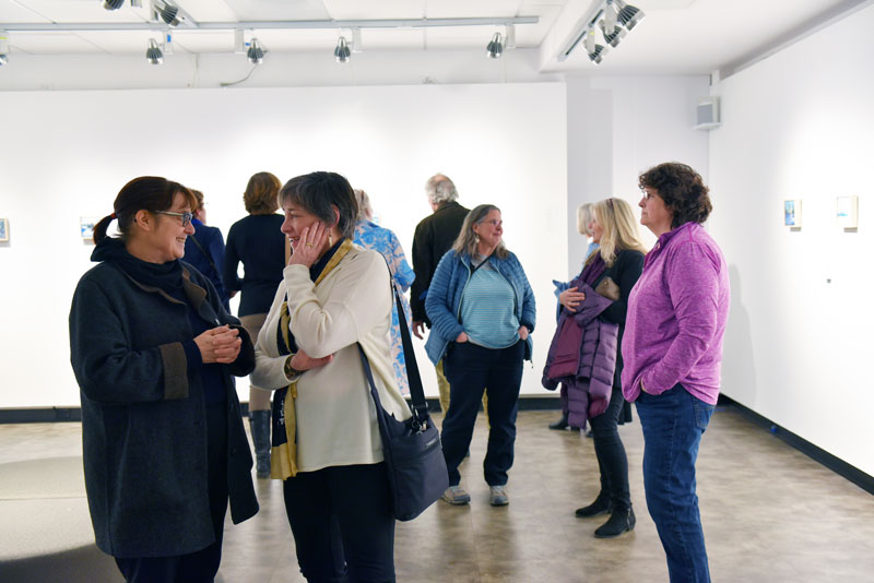 a group of people admiring artwork in Champlain's Art Gallery