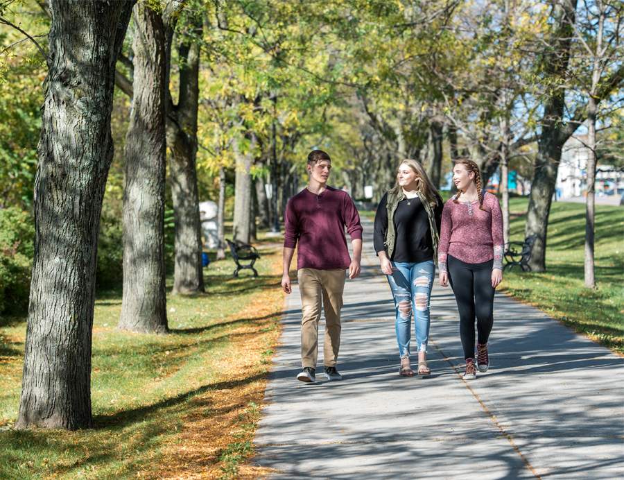 three students walking on the bike path