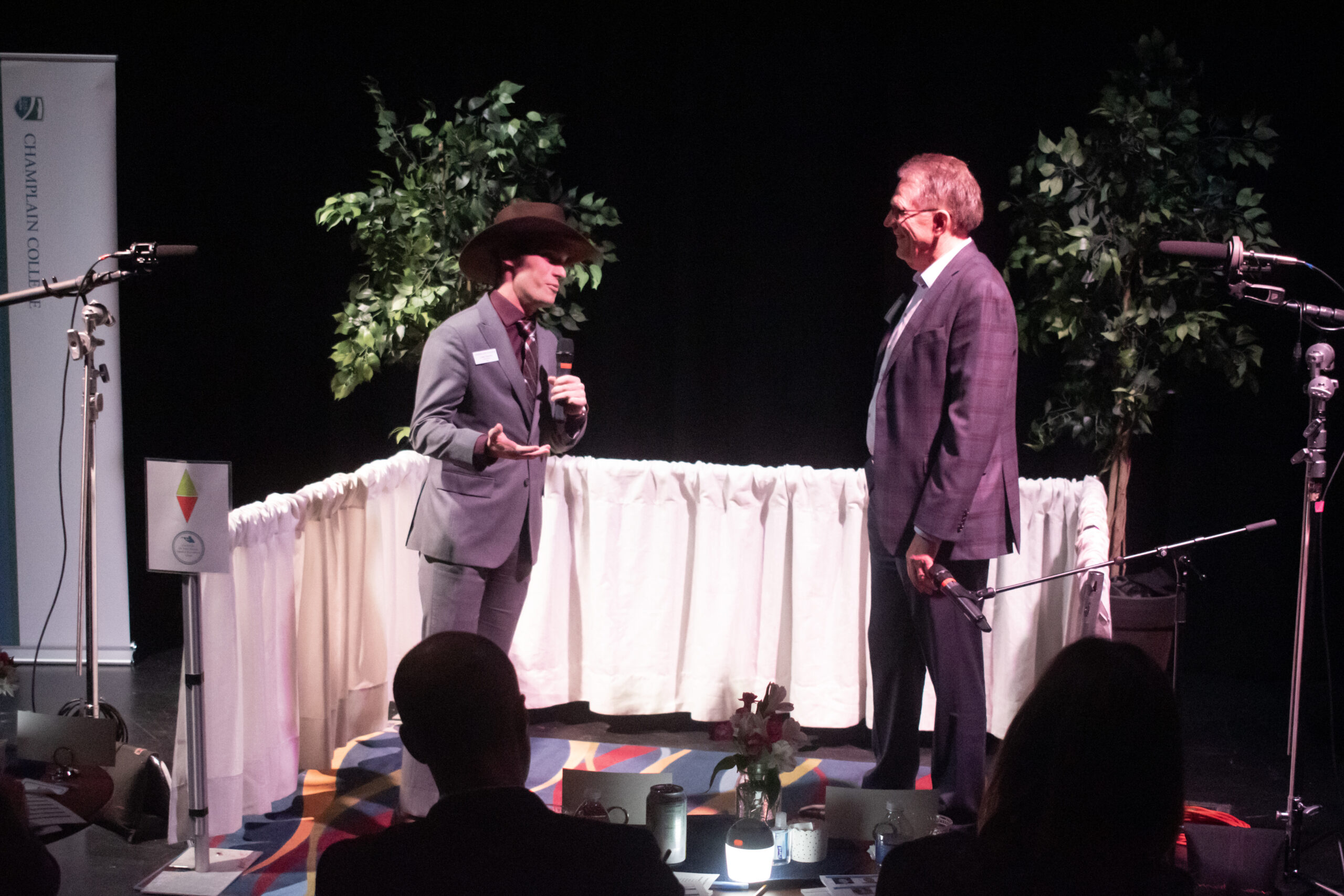 Caleb Secrest wearing a cowboy hat giving his elevator pitch to a faculty member