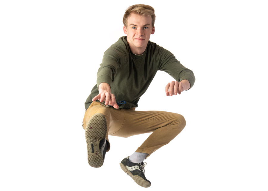 a student striking a jumping pose against a white background