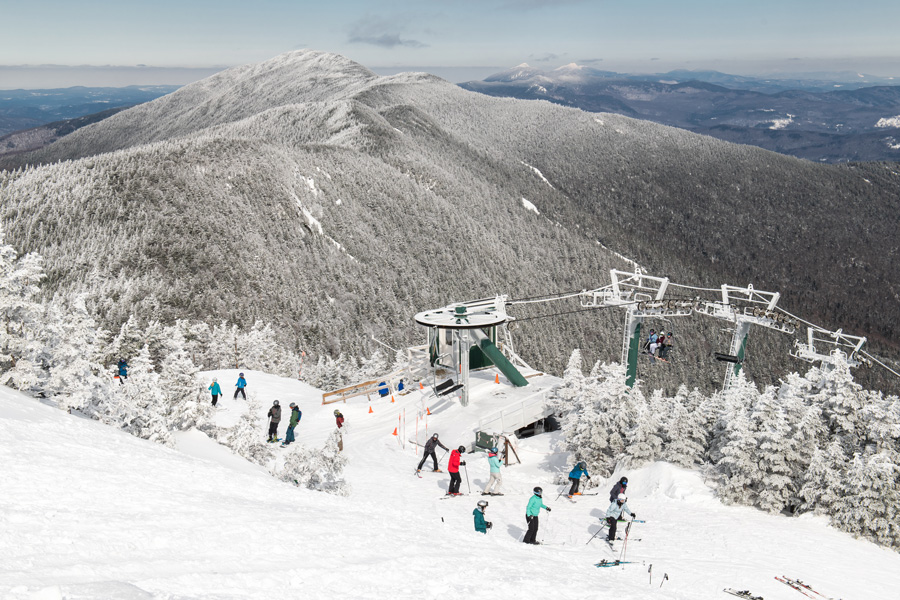snowy mountain with colorful skiers and snowboarders