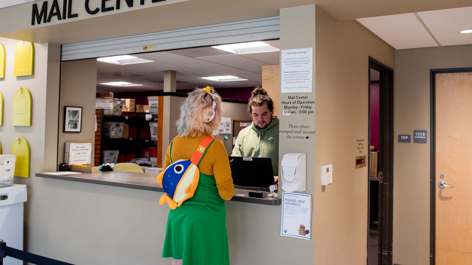 student work at mail center helps a customer