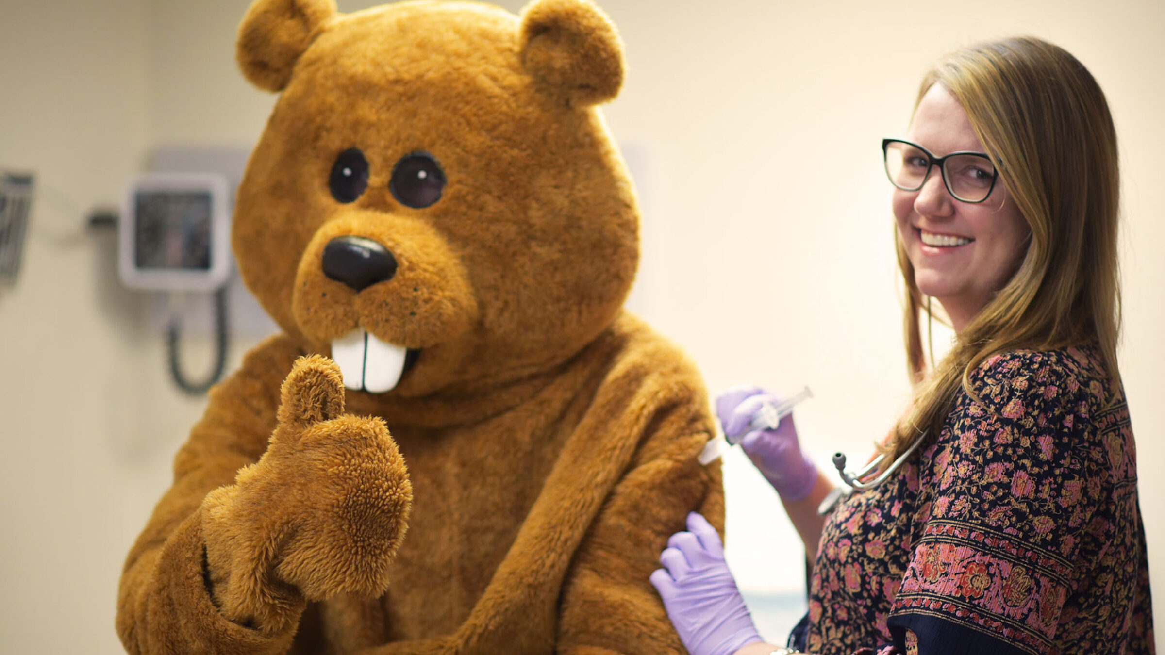 A nurse giving Chauncey a flu shot in the student health center clinic