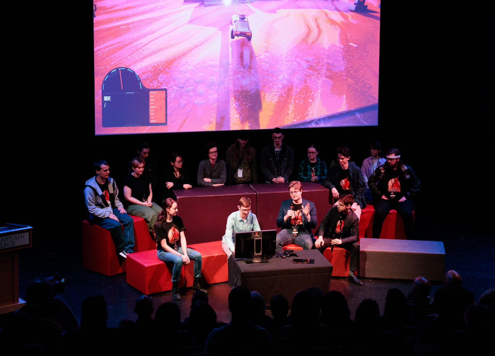 students presenting a video game at the game studio senior show on stage