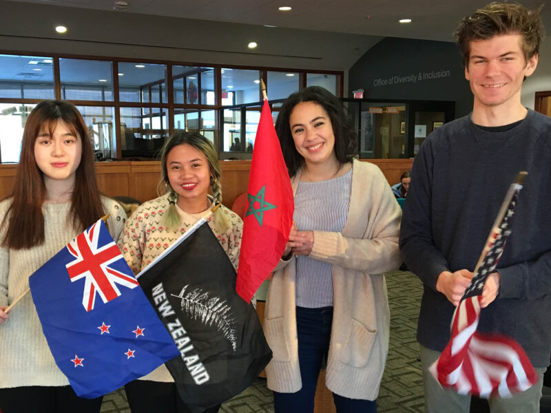 International students holding flags from their home countries