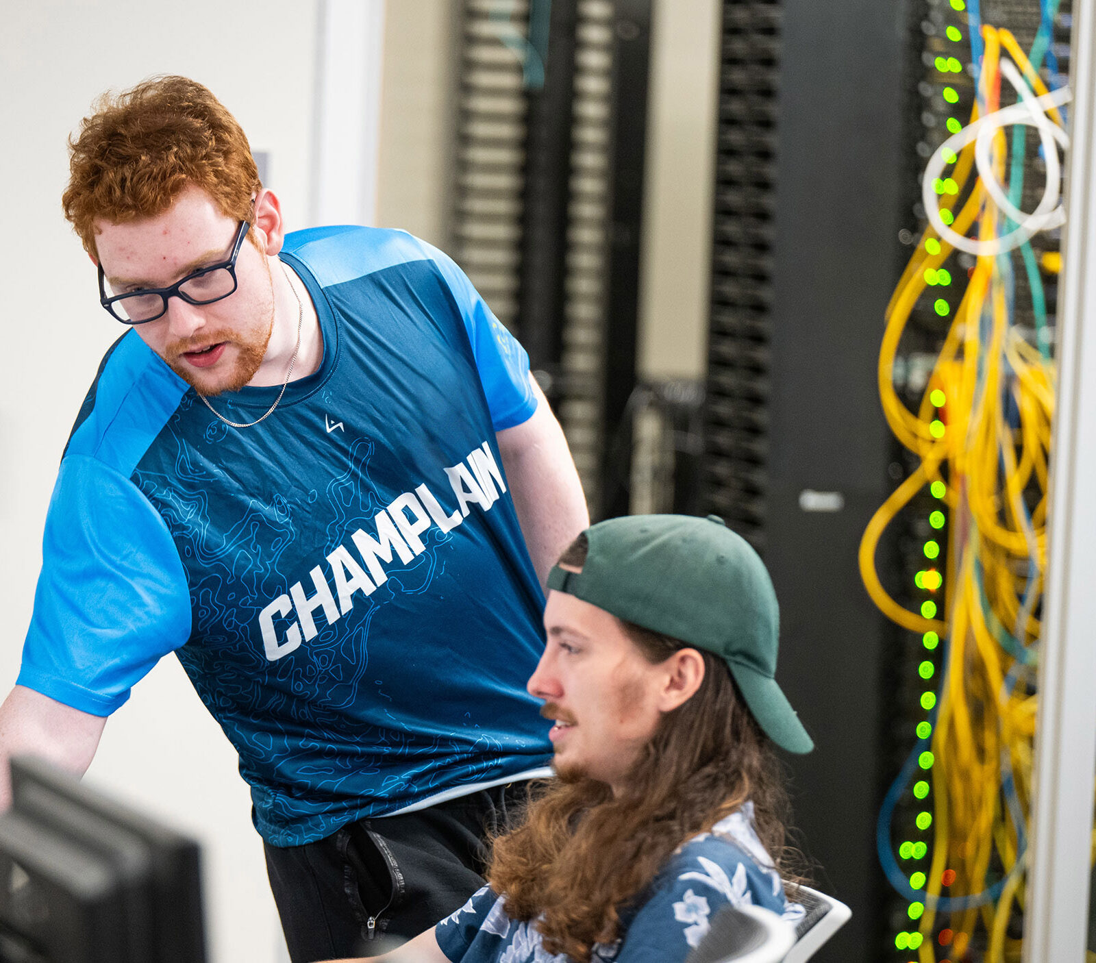 Two students work alongside each other at the Cyber Range at Champlain College.