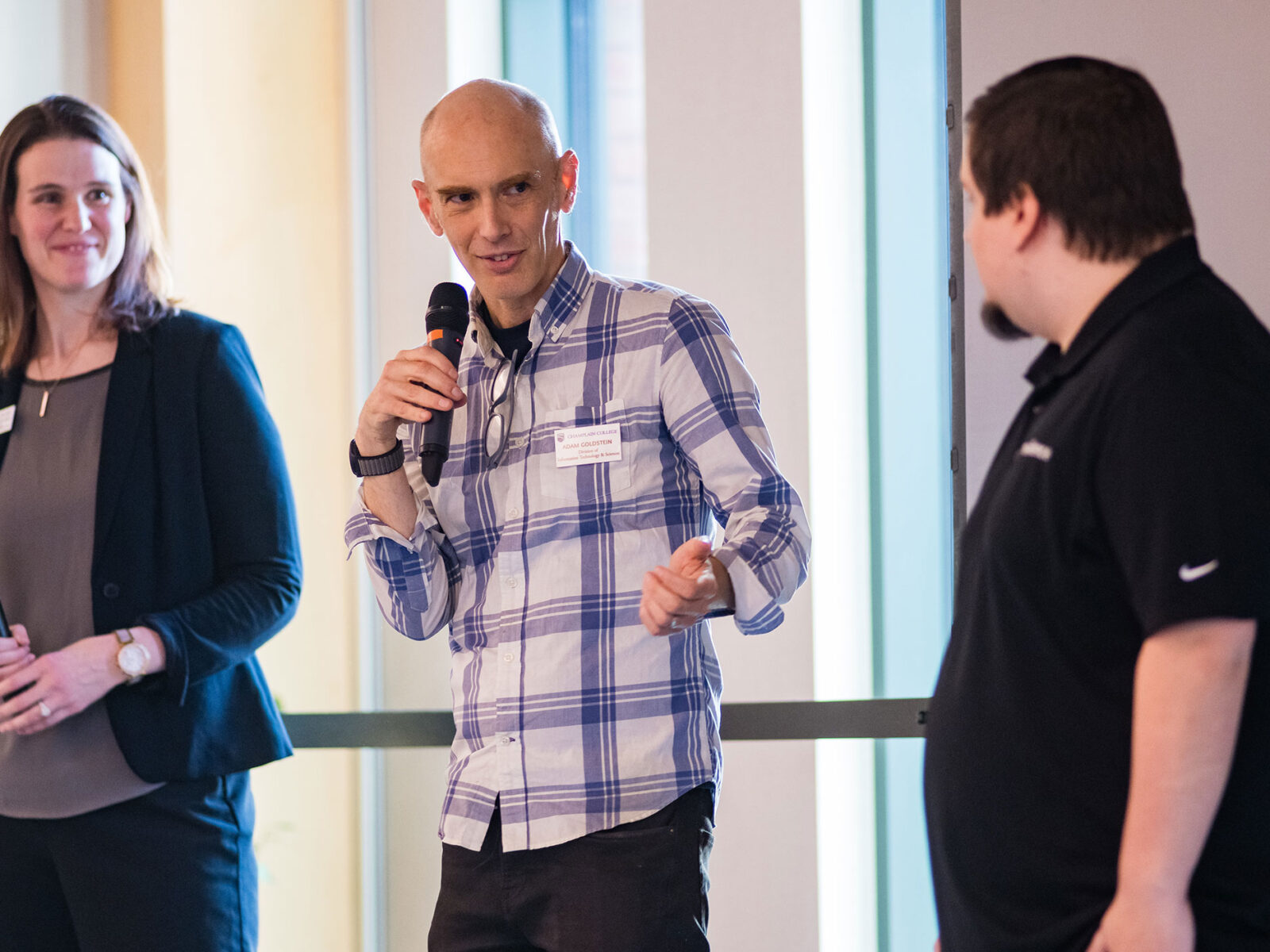adam goldstein on stage holding a mic