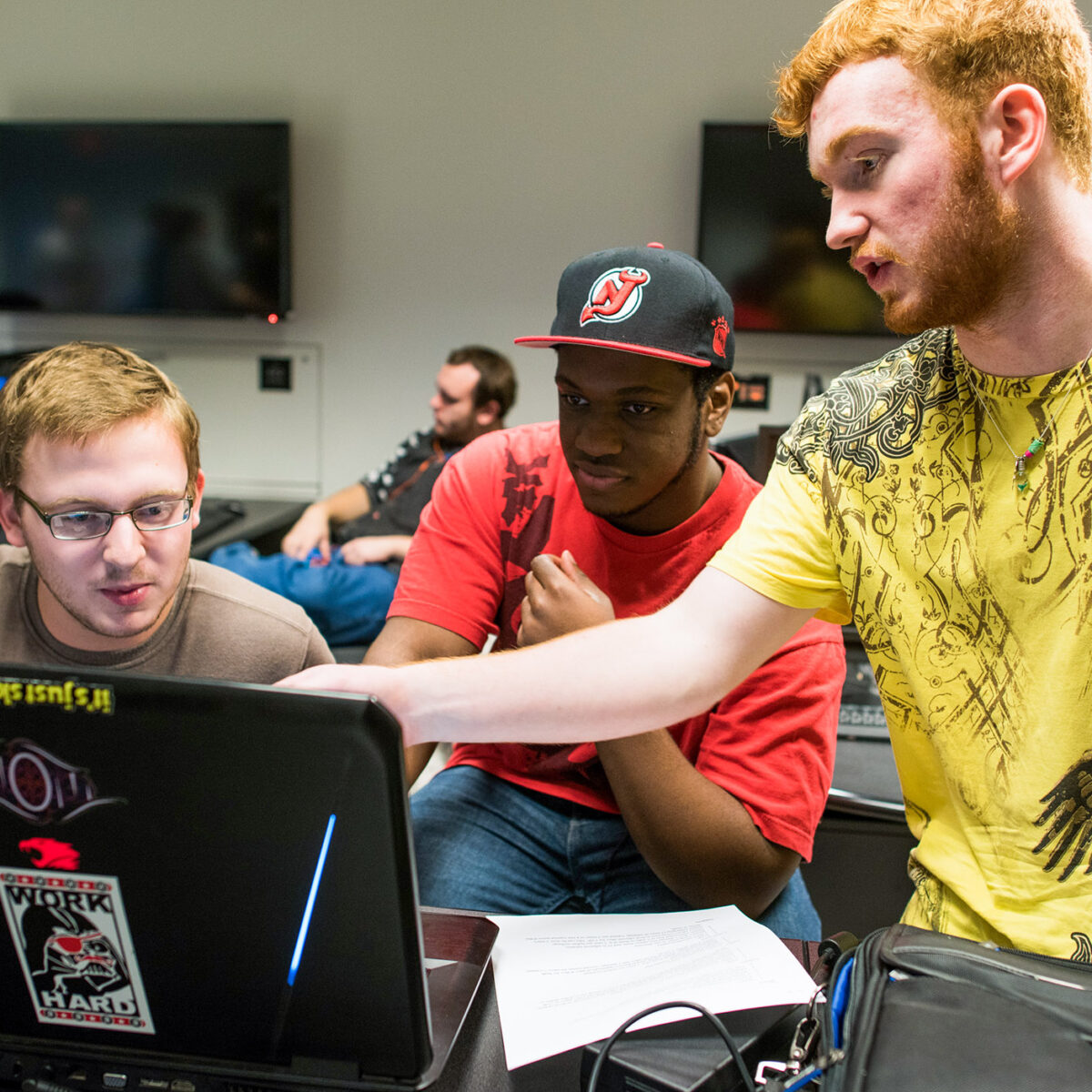 students collaborate pointing at a computer